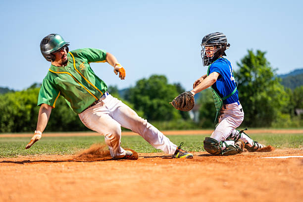 istock Baseball Player Slides into Home Plate, Catcher Attempts Tag 2235510155