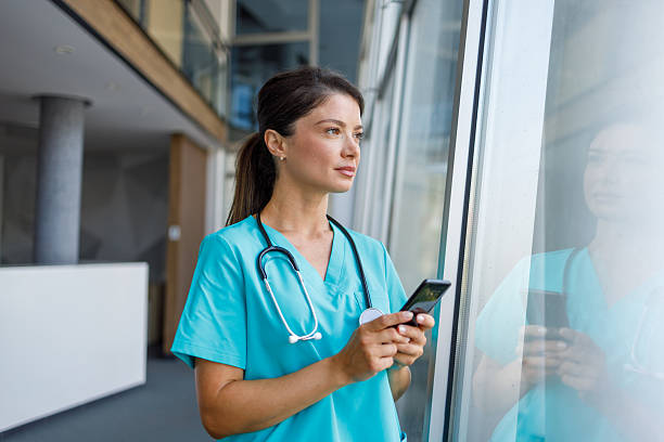 istock Female doctor using smartphone in hospital corridor 2235510964