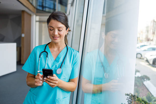 istock Smiling female doctor using mobile phone in hospital corridor 2235511022