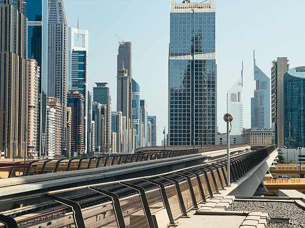 istock Modern Dubai cityscape with tall glass buildings, metro platform view, elevated train tracks, and futuristic skyscrapers 2235512191