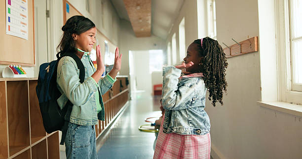 istock High five, girls and students in school, smile and knowledge with hello, learning and excited. Education, friends and children with gesture, happiness or greeting with academic development or support 2235513742