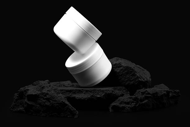 White plastic cosmetic jar with stone for mockup isolated on black background. Selective Focus.
