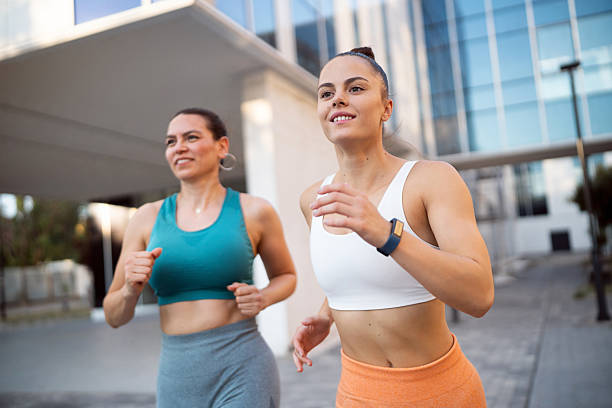 istock Smiling women keeping stride together during a lively outdoor run 2235516977