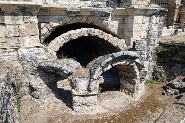 Sunlight illuminates the weathered stone arches and crumbling walls of the ancient roman baths in perge, turkey, offering a captivating glimpse into the city's rich history