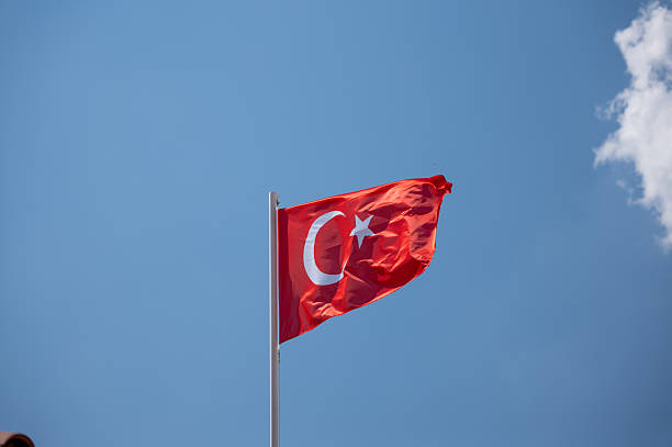 istock Turkish flag waving in the wind against blue sky 2235518900