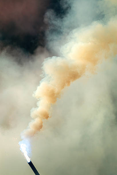Bengal torch burning with dense smoke outdoors, flare torch emitting heavy smoke cloud. Selective focus.