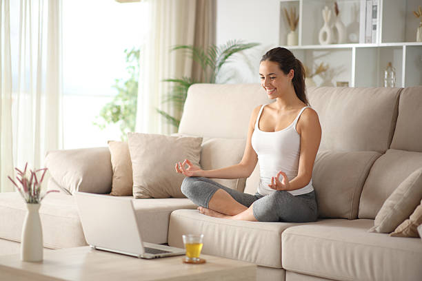 istock Happy yogi e-learning yoga online with a laptop 2235523356