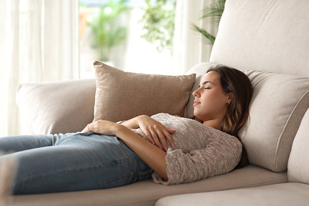 istock Woman sleeping on a chaise longue sofa at home 2235526439