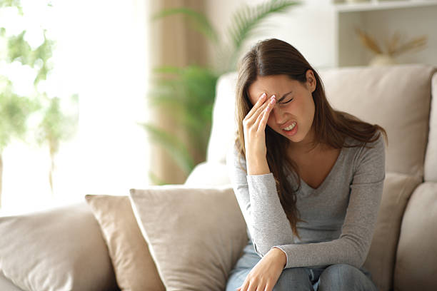 istock Woman suffering head ache being alone at home 2235526448