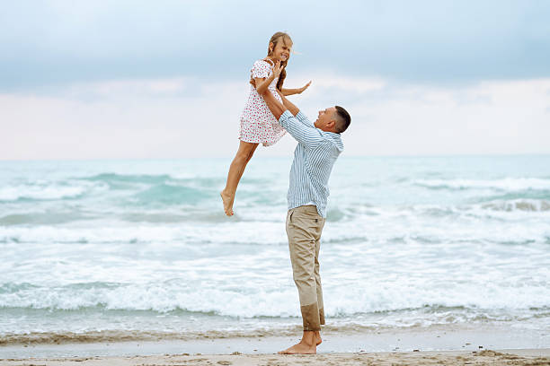 istock A father and his little daughter stroll along the seashore, holding hands. 2235528832