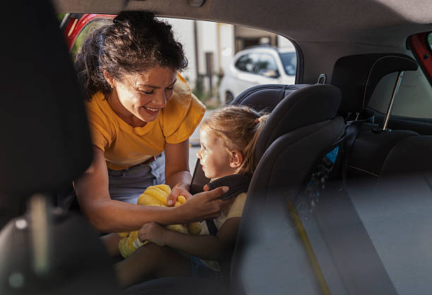 istock Mother helps daughter fasten seatbelt in car 2235529202