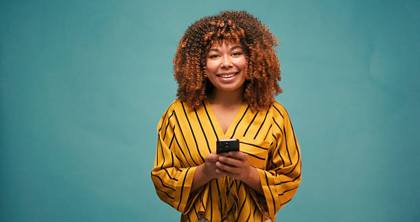 istock Woman smiles warmly as scrolls through feed on smartphone 2235531040