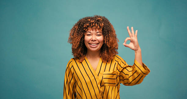 istock Happy woman smiling brightly and confidently forms Okay gesture 2235531072