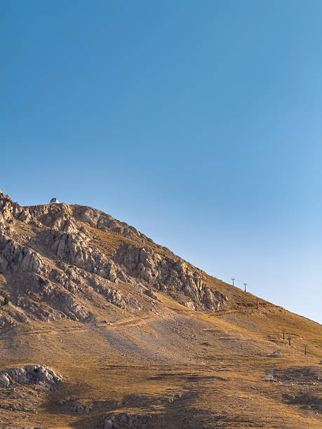 istock Wide mountain slope under clear sky with ski lift poles 2235532539