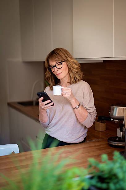 istock A woman standing in her kitchen and drinking her morning coffee 2235532544