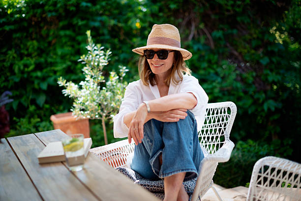 istock Cheerful smiling middle aged woman sitting at home at back yard 2235532881