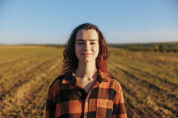 istock Young female farmer smiling and looking at camera in rustic countryside field 2235534972