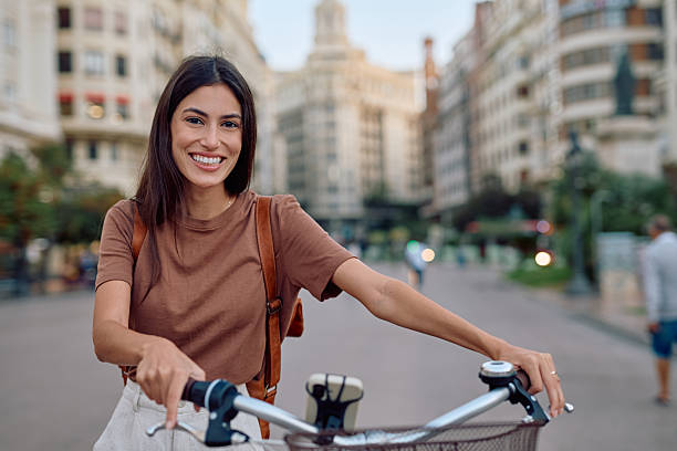 istock Young woman smiling while riding bicycle in Valencia, Spain 2235537352