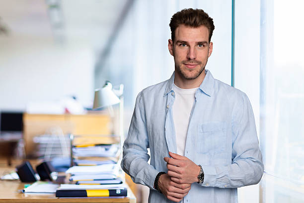 istock Young business man standing in a modern office space 2235537923