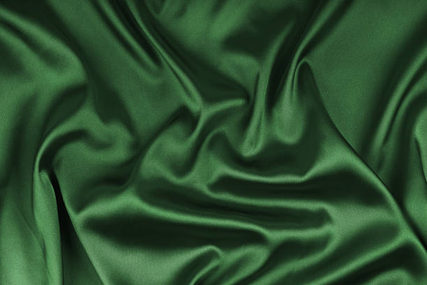 istock Crumpled, wrinkled green colored glossy silk satin texture. Shiny smooth fabric with soft folds 2235539165