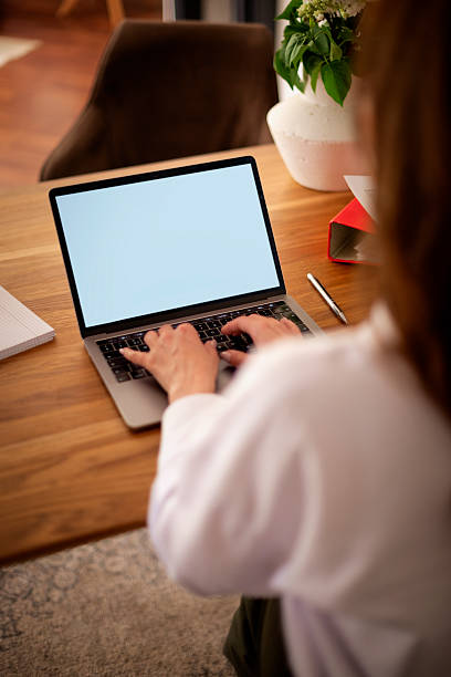 istock Rear view of a woman typing on the keyboard, empty screen 2235540321