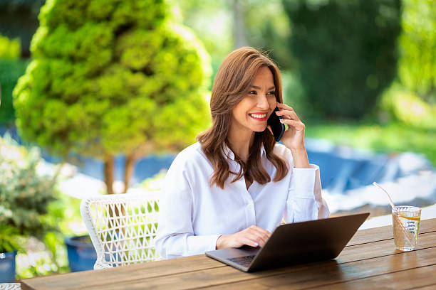 istock Smiling woman sitting outdoors and working from home 2235540409