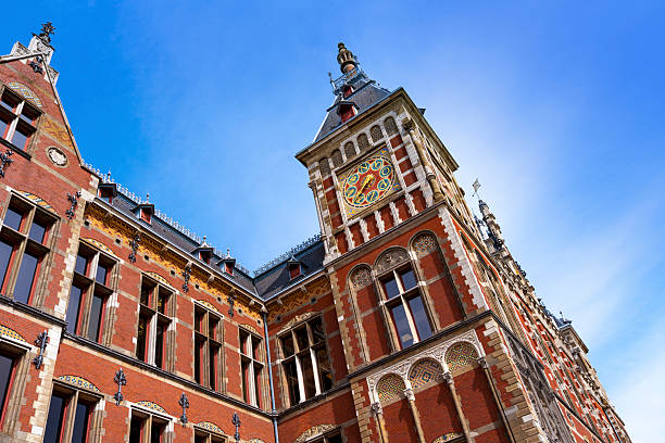 Amsterdam Central Station red brick historic facade in Netherlands under sunny sky