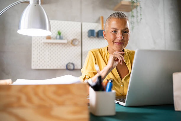 istock Smiling professional woman working on a laptop in a bright modern office 2235541178