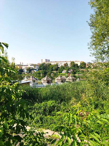 Serene lakeside view with thatched huts and lush greenery
