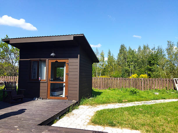 Cozy cabin surrounded by lush greenery and blue sky