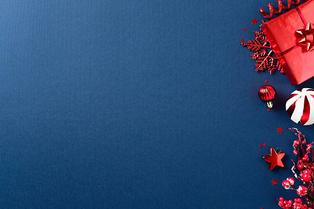 istock Christmas composition with red gift, baubles, snowflakes, berries, and stars on dark blue background. 2235543201