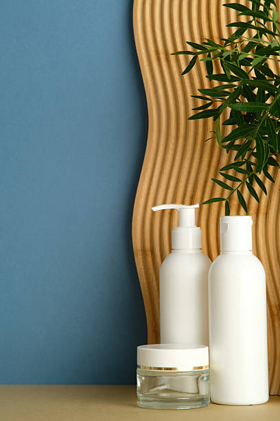 istock Minimalist skincare composition with two white clean bottles and moisturizer cream jar on blue and wavy wooden panel background. Beauty SPA, natural cosmetic concept. 2235545149