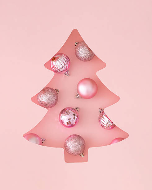 istock Winter composition with Xmas baubles visible through a Christmas tree shaped gap on pastel pink background. Minimal Christmas and New Year concept. Creative festive holiday layout. Flat lay, top view. 2235548795