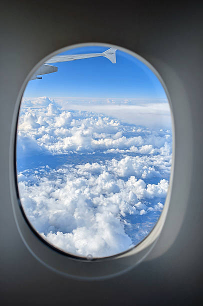 istock clouds and blue sky with an airplane wing from the window during an intercontinental flight 2235550744