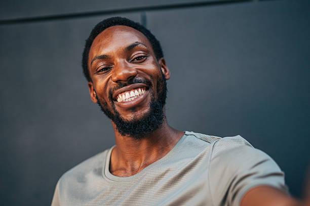 istock Young man smiling and taking a selfie against a gray background 2235551807