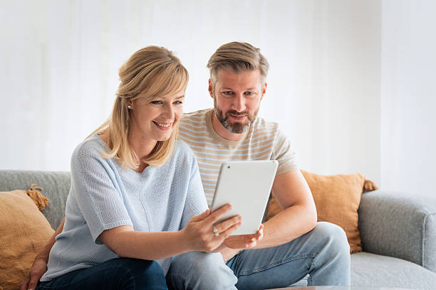 istock Happy couple relaxing at home and using a digital tablet 2235551936