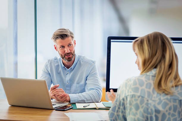 istock Group of business people sitting at office desk and using laptop and computer for work 2235551947