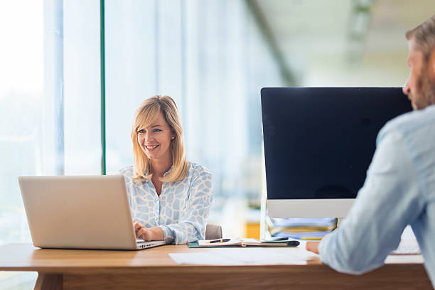 istock Group of business people sitting at office desk and using laptop and computer for work 2235551955