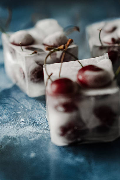 Red Cherry In Ice Cubes Against White Background