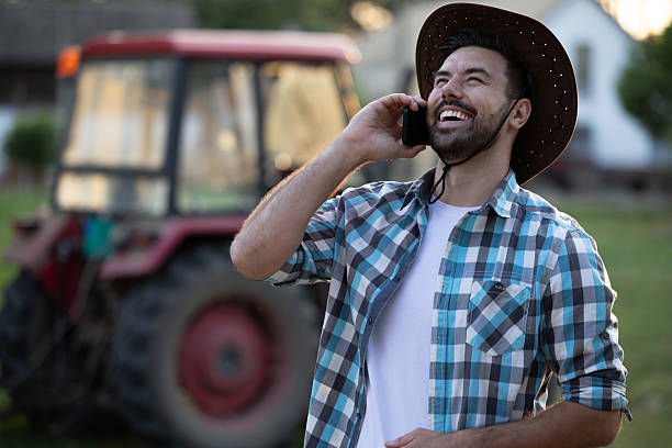istock Man with a hat talking on phone and smiling on farm 2235554304