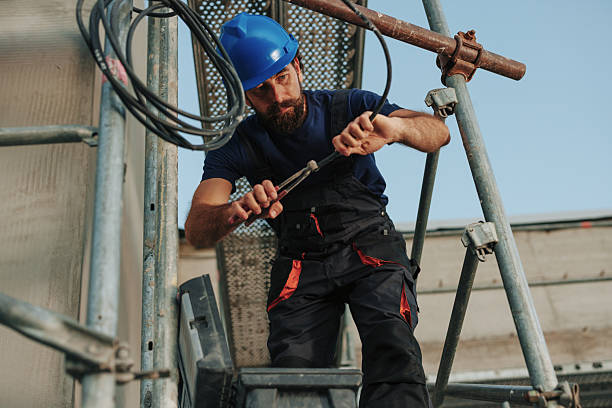 istock Electrician working on scaffolding is cutting and stripping electrical wires 2235554457