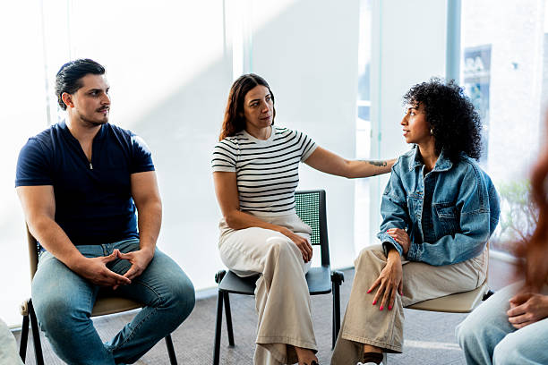 istock Mid adult woman talking during group therapy session 2235555939