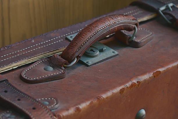 An antique trunk latch details are highlighted in a close-up shot, revealing texture and aged aesthetic.