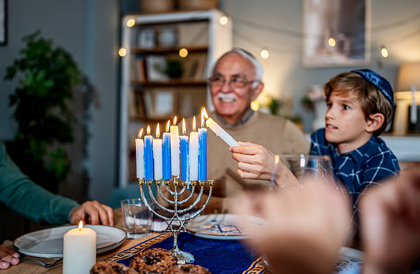 istock Family lighting Hanukkah menorah during festive dinner 2235560997