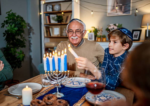 istock Family lighting Hanukkah menorah during festive dinner 2235561775