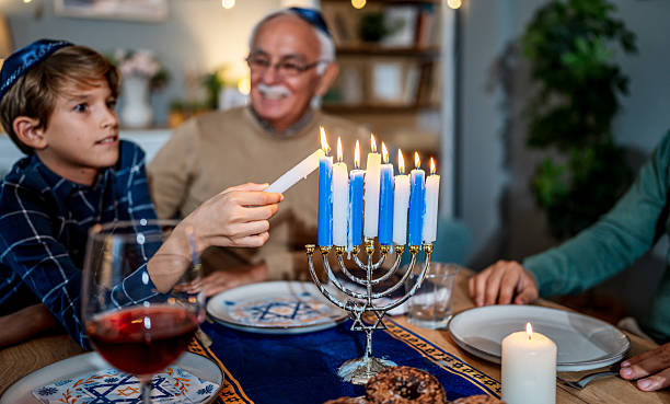 istock Family lighting Hanukkah menorah during festive dinner 2235562614