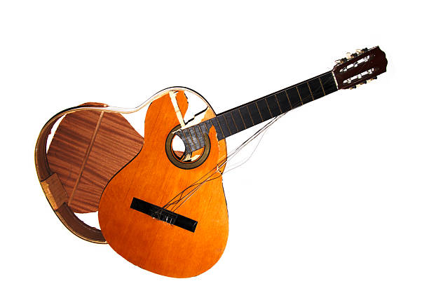 A broken smashed acousitic guitar music instrument on white background