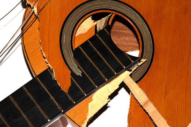 Overhead view of broken guitar falling on floor.