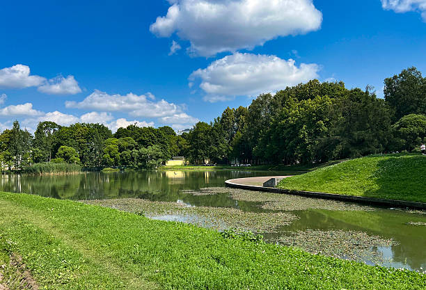 istock Serene park landscape with calm water and vibrant greenery during a sunny day 2235564788