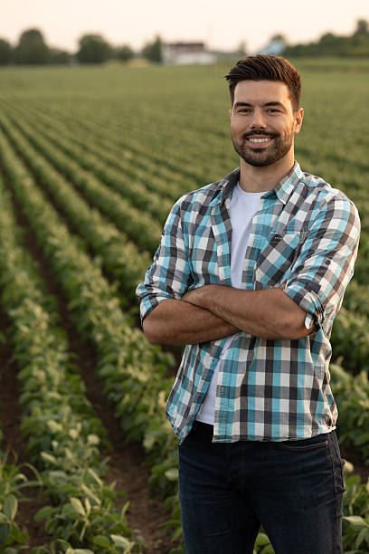 istock Smiling man poses in green soybean field during golden hour 2235565140